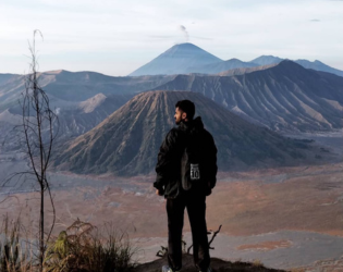 Person overlooking a volcanic mountain landscape.